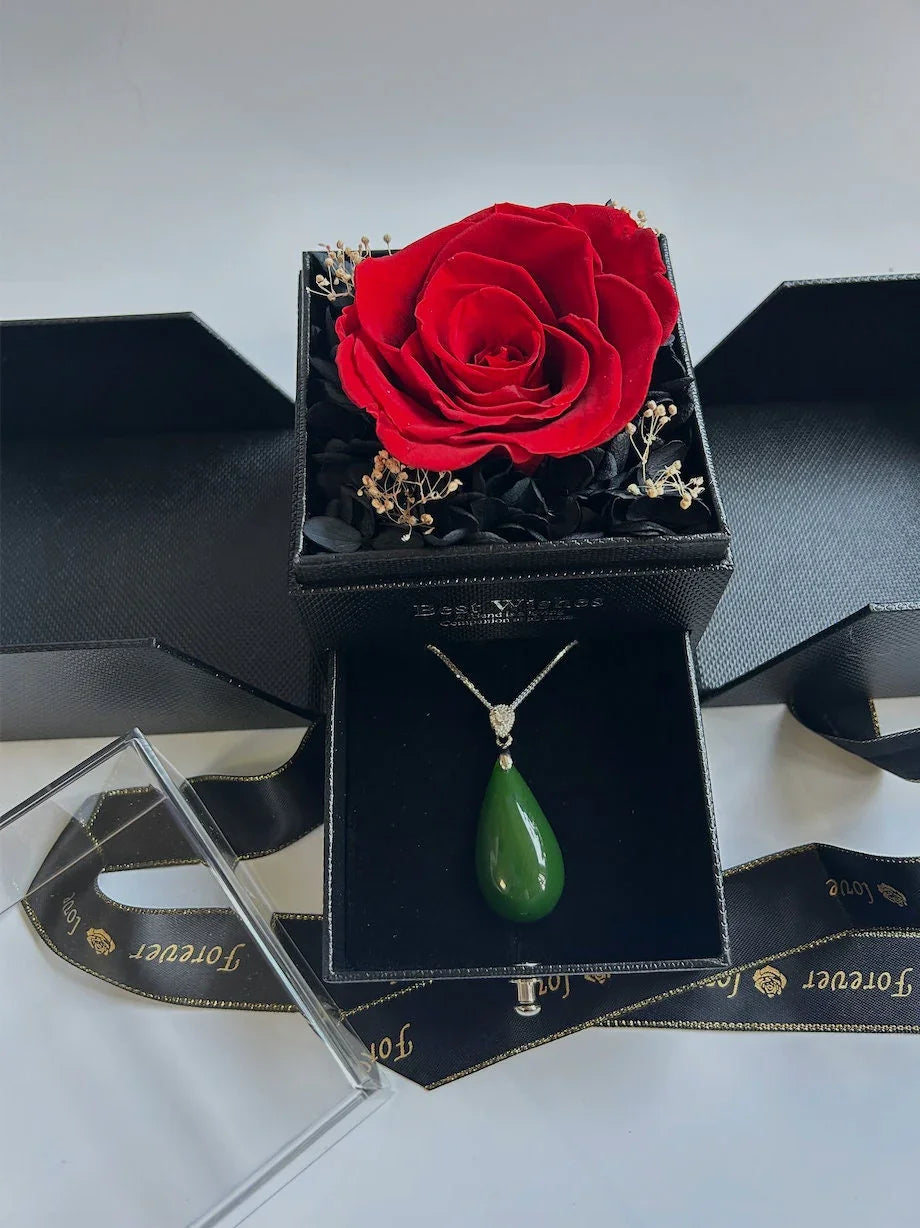 A piece of dark jade teardrop pendant necklace in a black gift box decorated with real preserved red rose