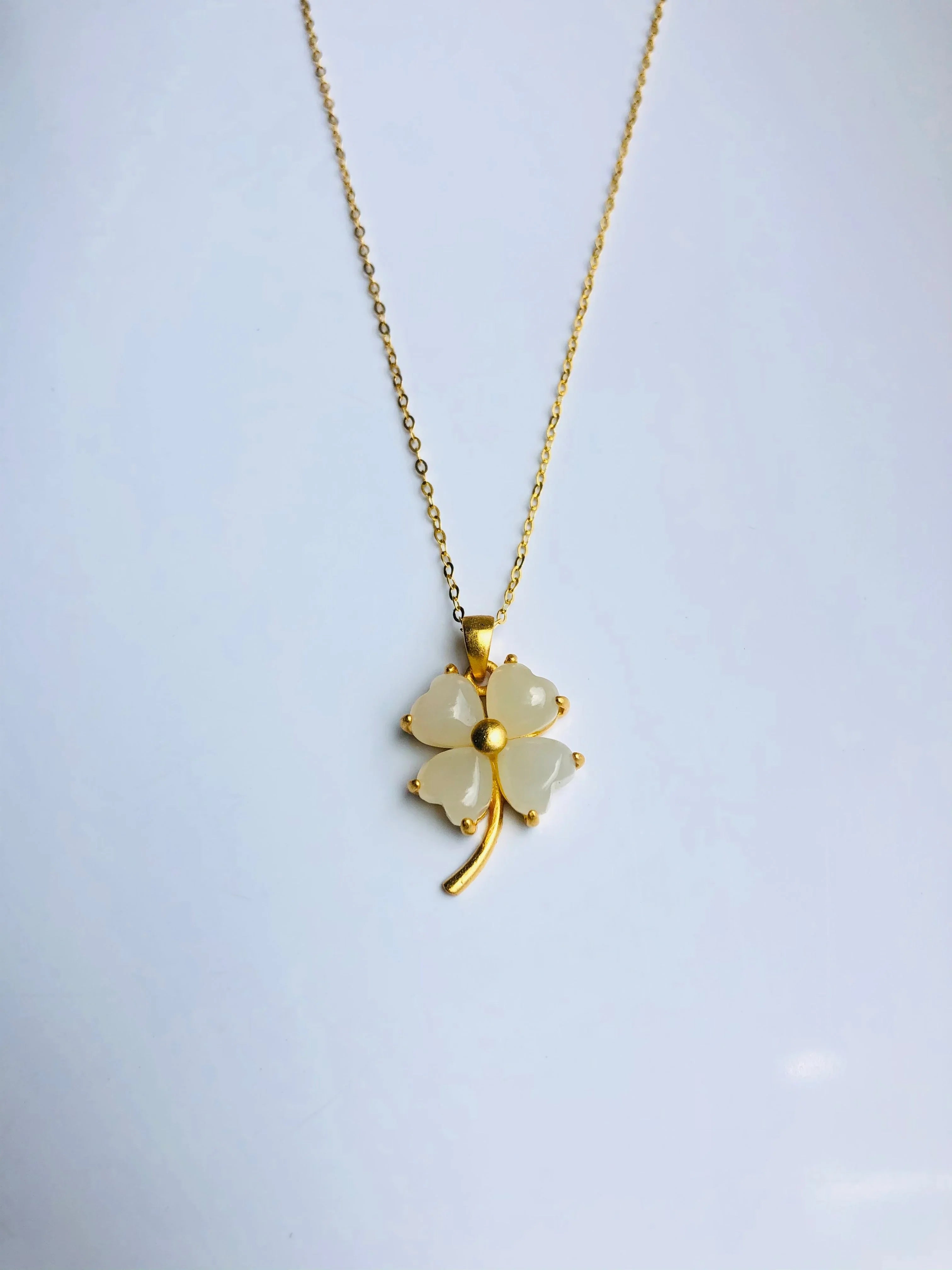 A white jade clover shaped pendant with 18k gold plated necklace