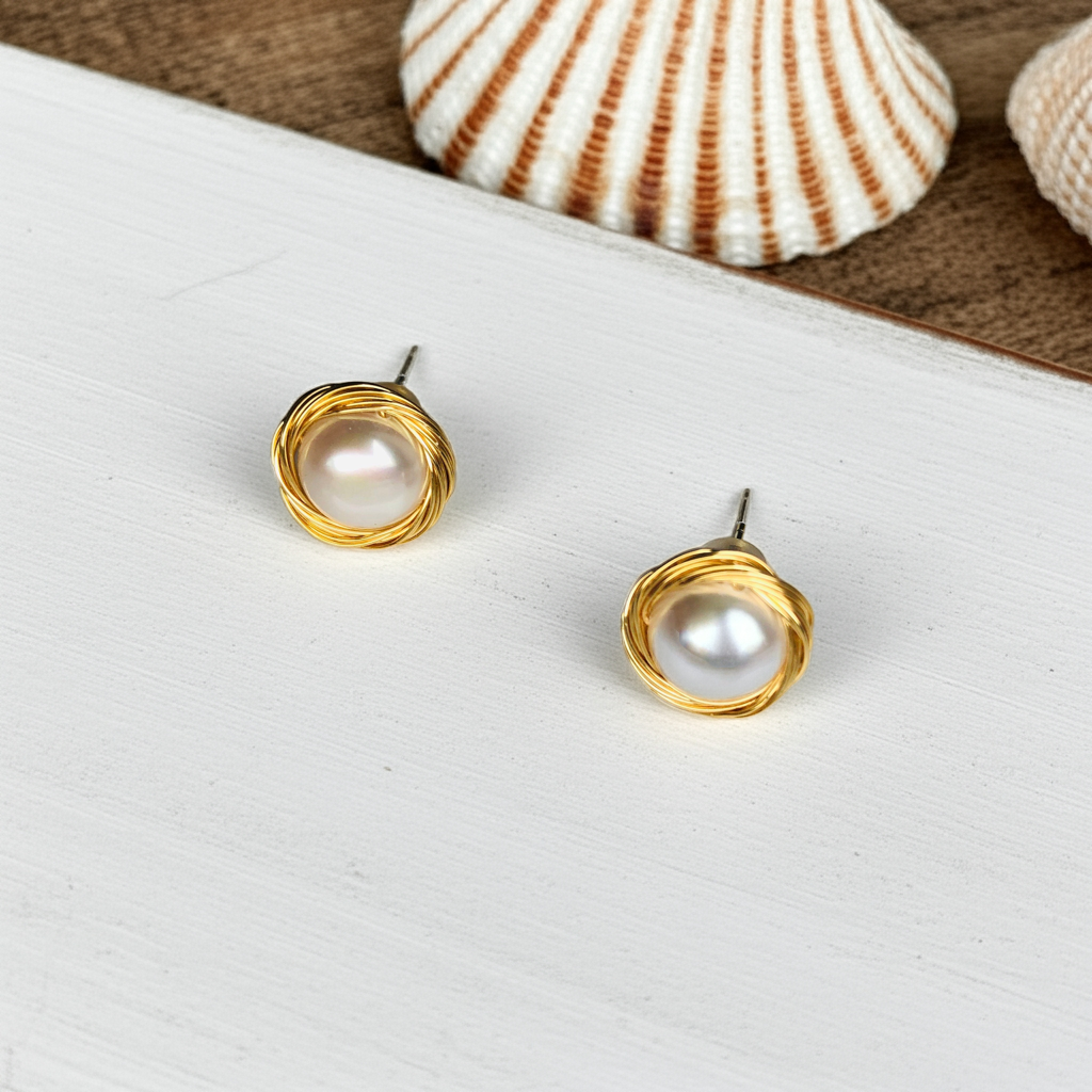 pearl earrings on a white board with shell on the background