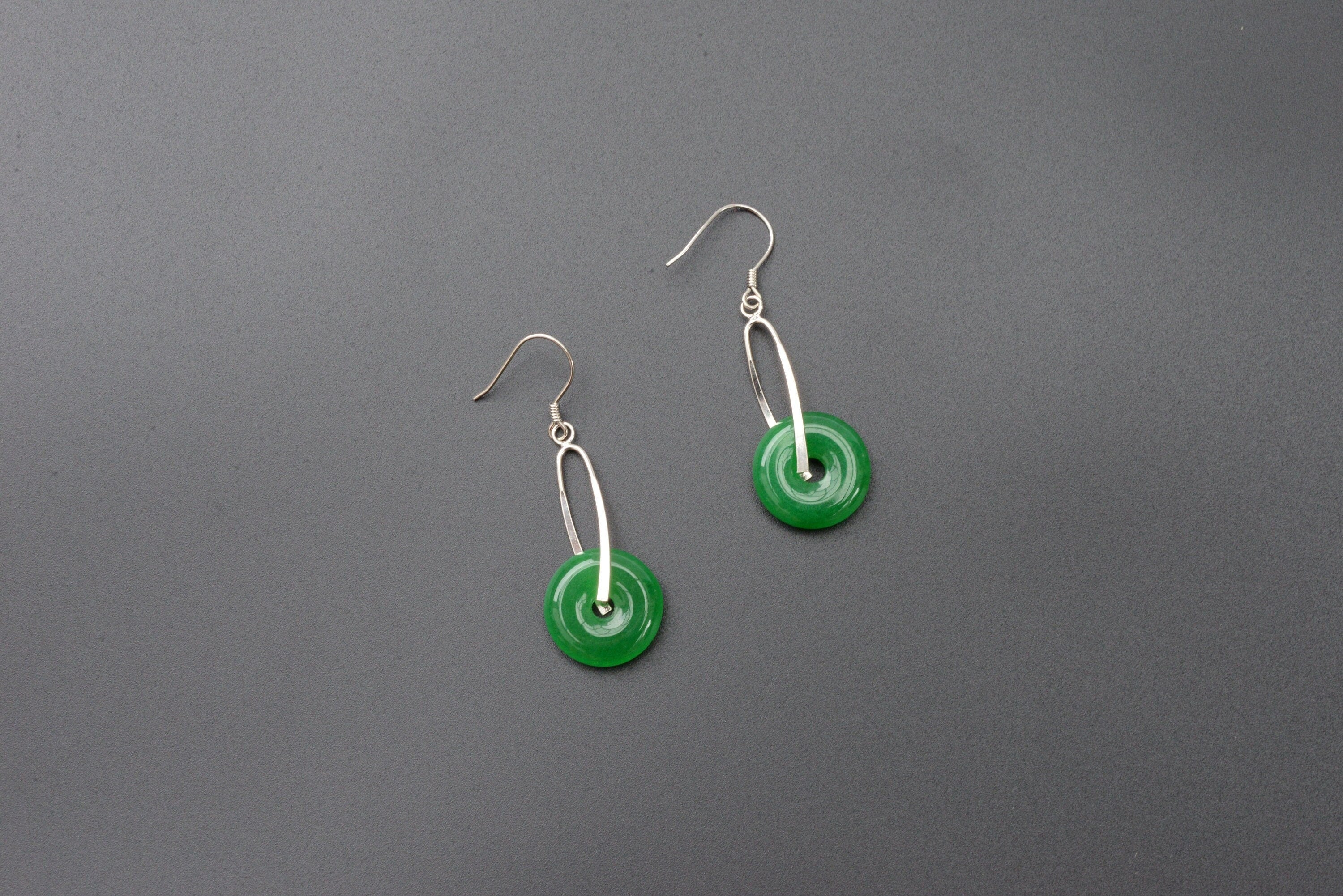 Front view of green jade donut earrings with sterling silver hooks and polished finish