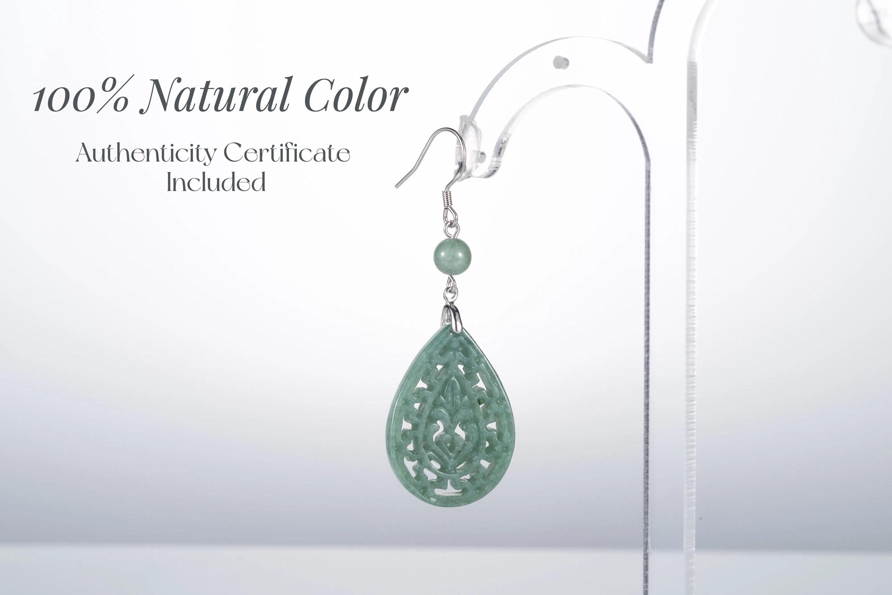Close-up of authentic jade teardrop earrings with intricate silver vintage frame