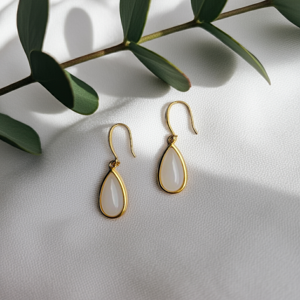 Front view of 18k gold white jade teardrop earrings with minimalist design