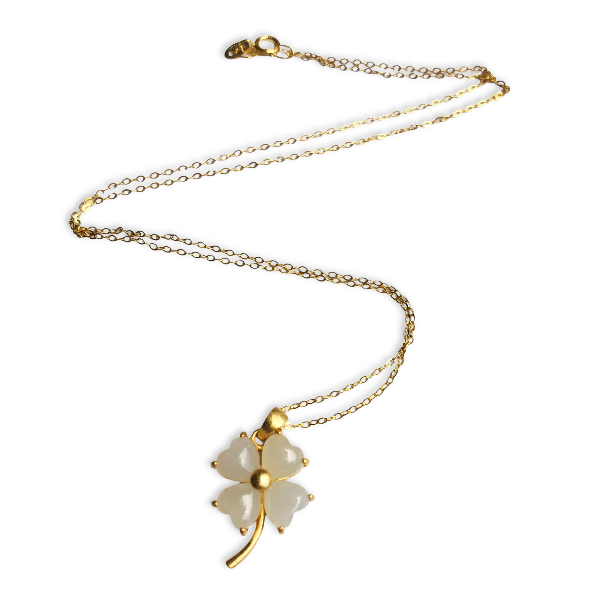 Gold necklace with a white pendant on a white background