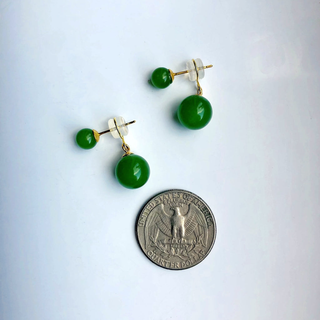 Green bead earrings on a white background with a quarter for scale.