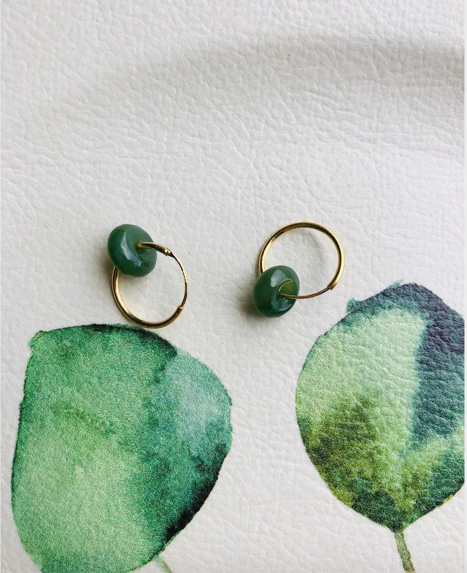 Green earrings on a white background with green leaf designs