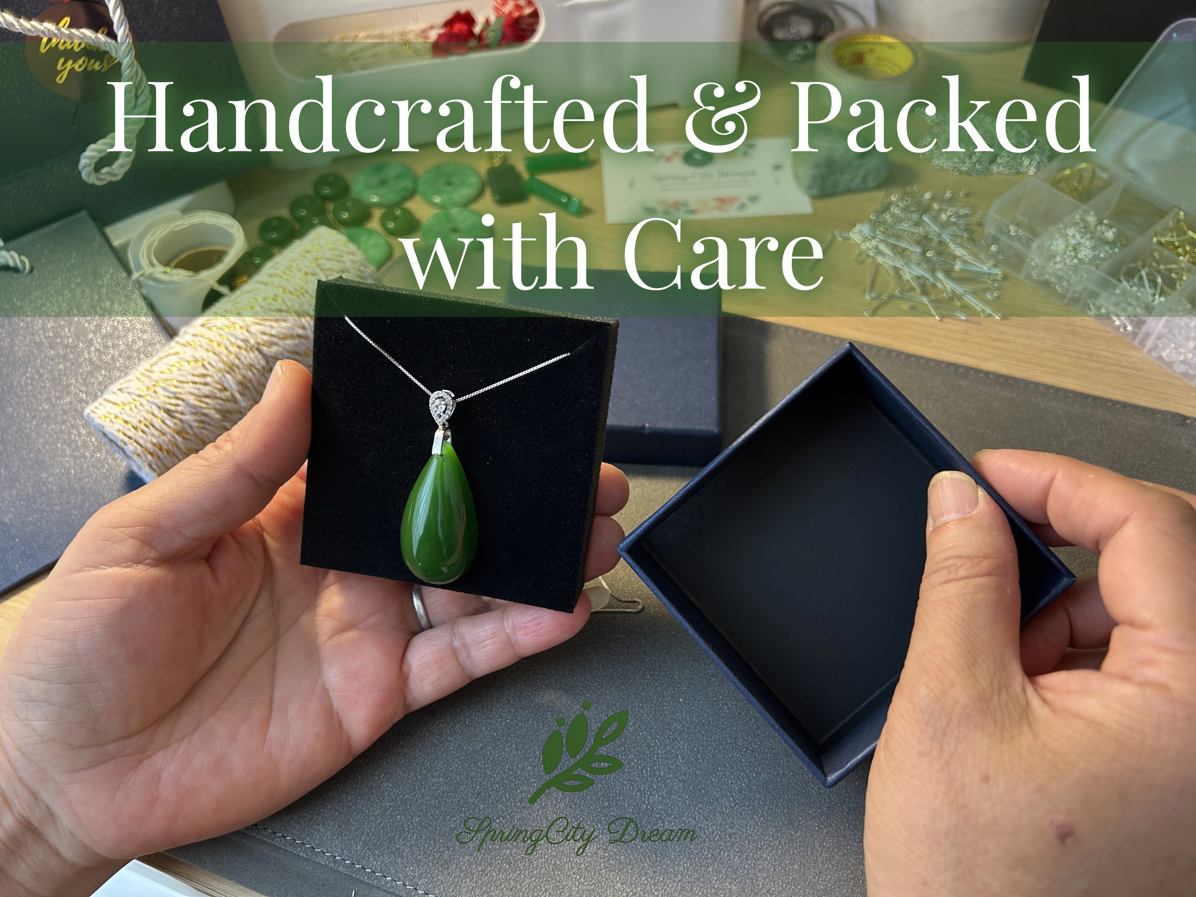 Person holding a green pendant in a black box with 'Handcrafted & Packed with Care' text and Spring City Dream logo.