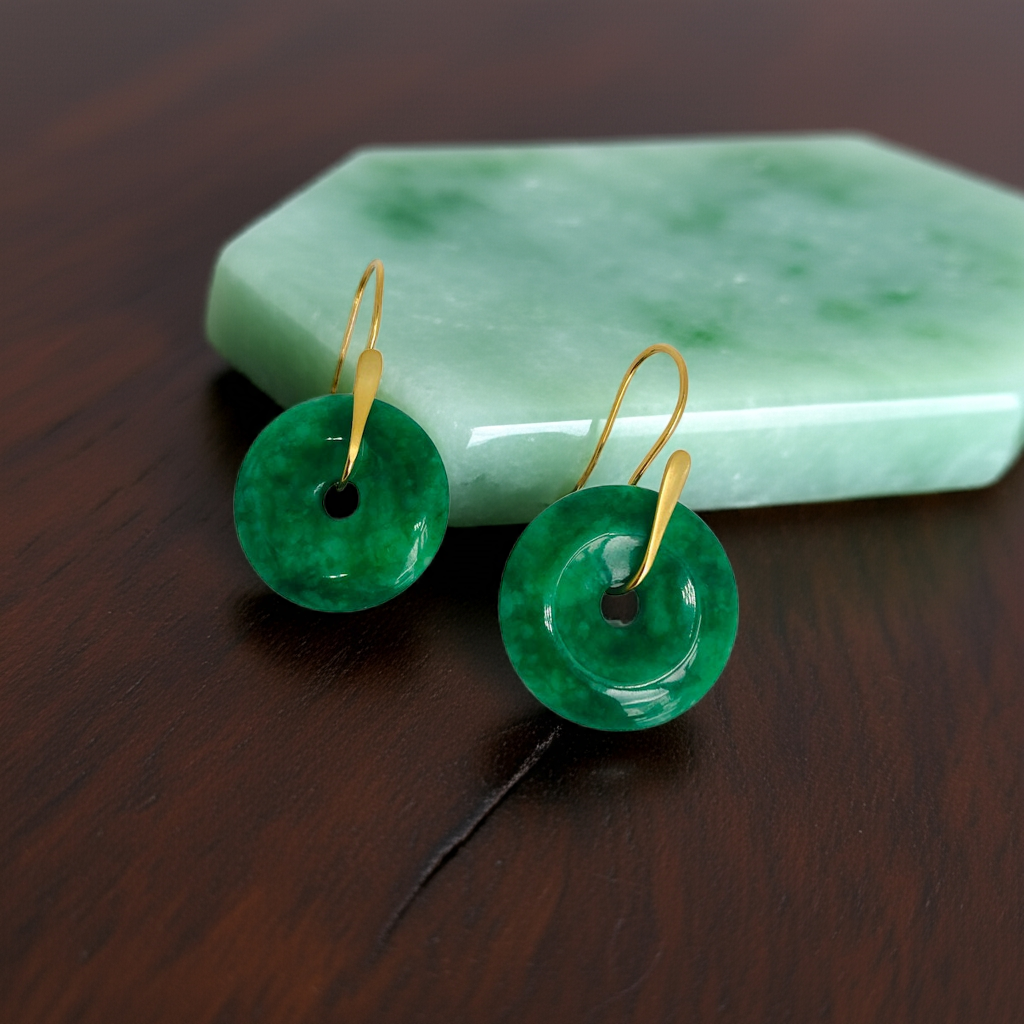 big circle jade hanging earrings against a piece of jade stone