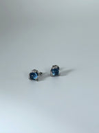 Front view of tiny snake eye stud earrings with blue gemstone set in sterling silver