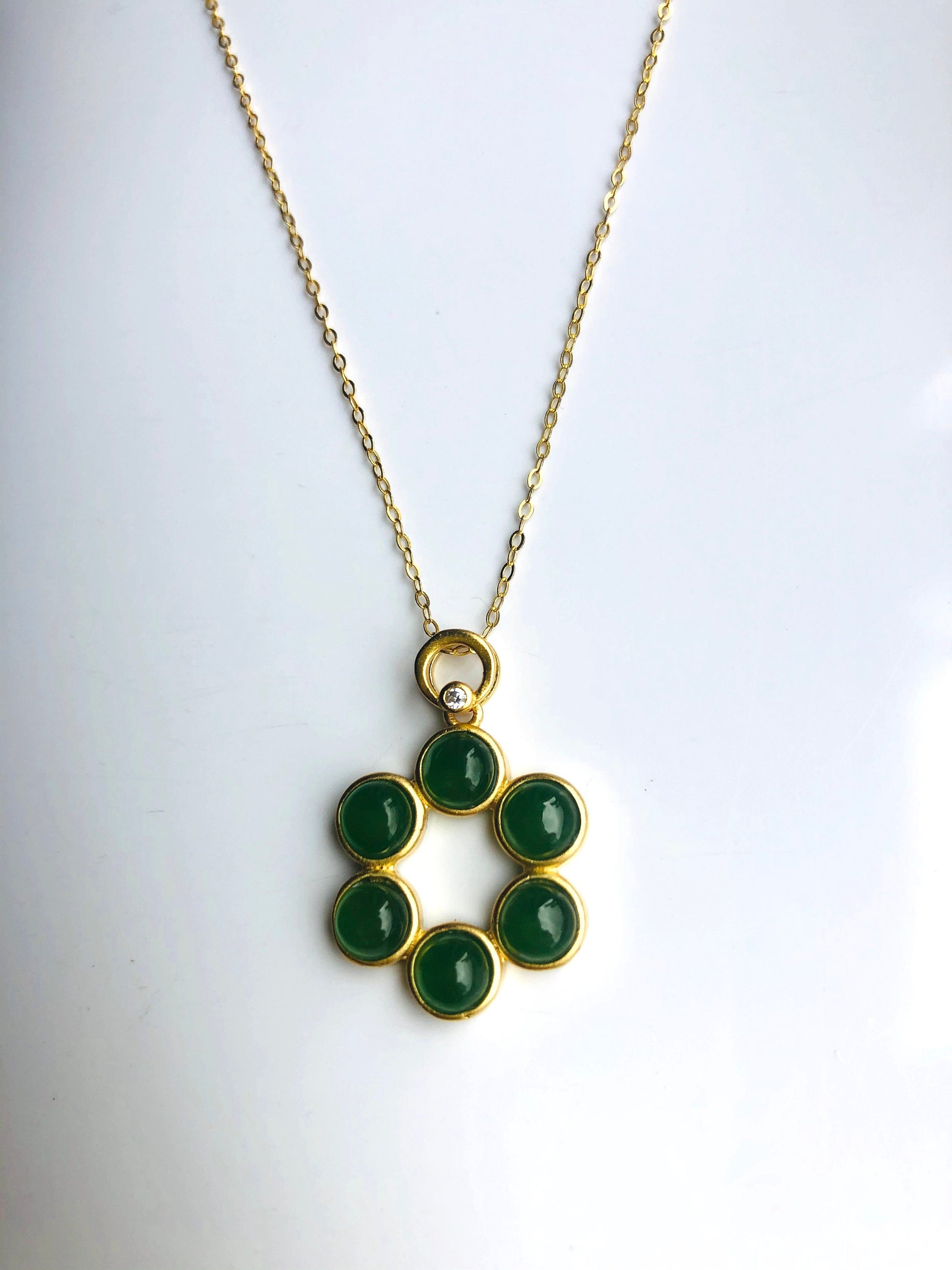 Close-up of natural green jade and gold pendant details
