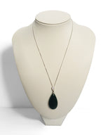Necklace with a green teardrop pendant on a mannequin bust against a white background