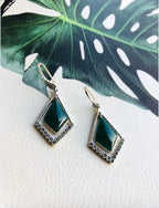 Front view of dark green diamond-shaped jade earrings with sterling silver hoops on leaf
