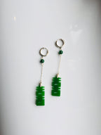 A pair of long dangle earrings featuring dark green jade characters attached to 925 sterling silver hooks.