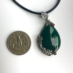 Teardrop jade necklace shown next to a coin to illustrate pendant size