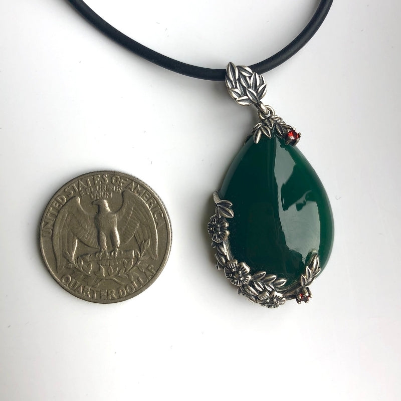 Teardrop jade necklace shown next to a coin to illustrate pendant size