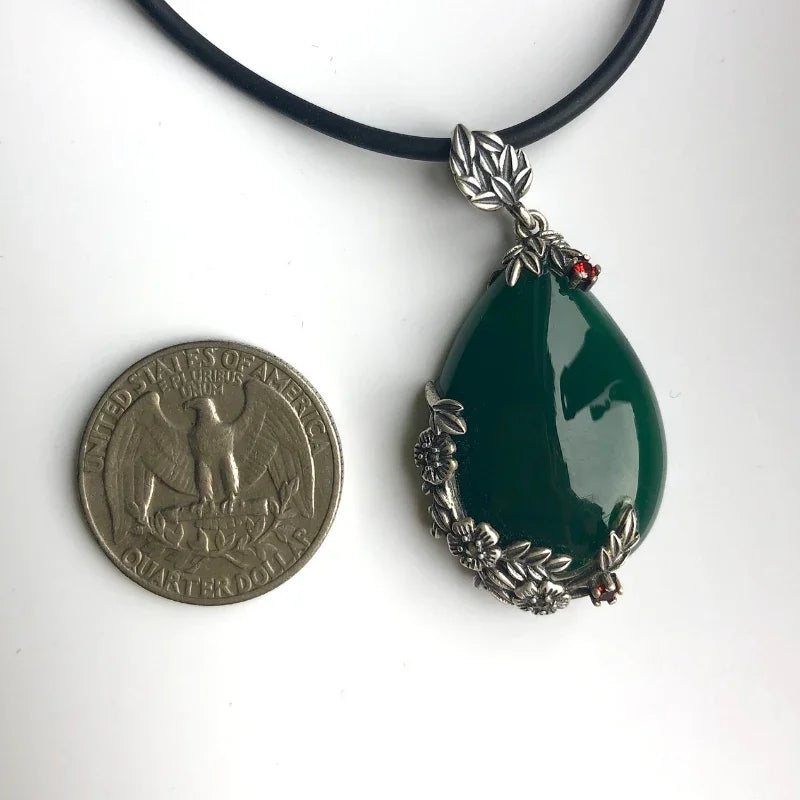 Teardrop jade necklace shown next to a coin to illustrate pendant size