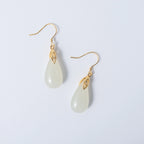 Modern white jade drop earrings in sleek gold design with teardrop silhouette on a white background