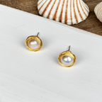 pearl earrings on a white board with shell on the background