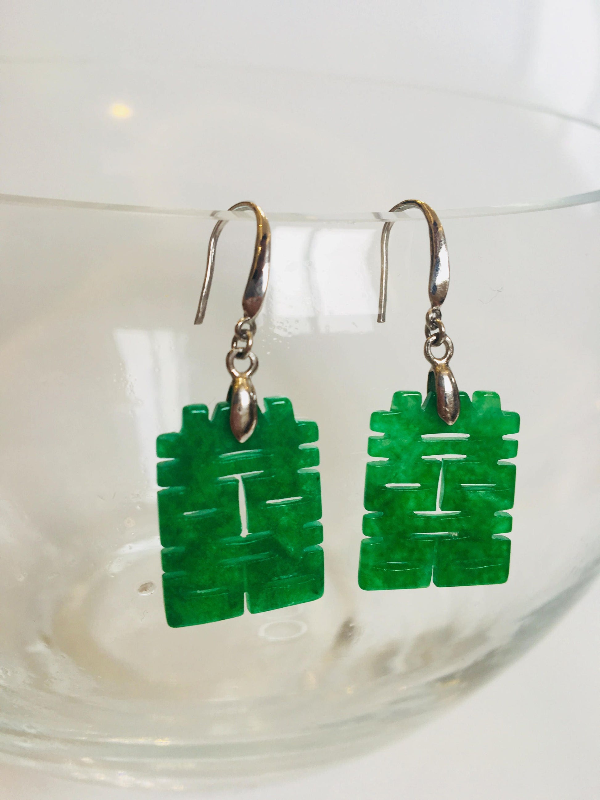 Side angle of jade dangle earrings featuring Chinese character design

