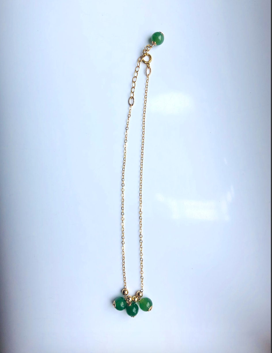 Gold-filled anklet with jade beads shown from side angle with focus on clasp and chain