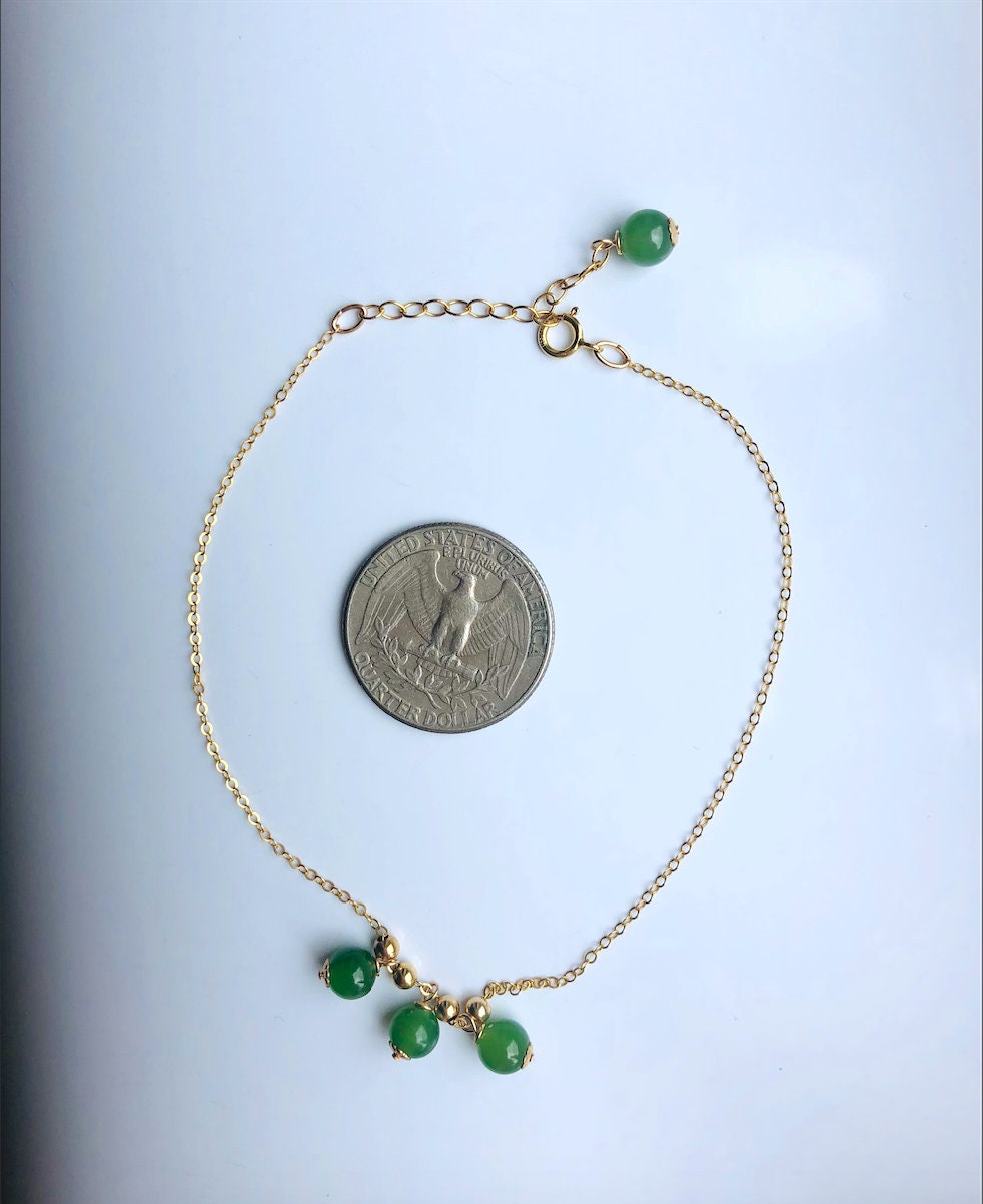 Green jade anklet with 14k gold-filled chain shown next to a US quarter coin for size reference