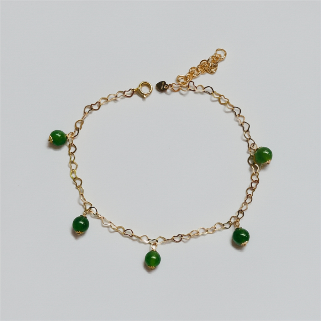 Close-up of real jade beads and gold heart charms on adjustable bracelet

