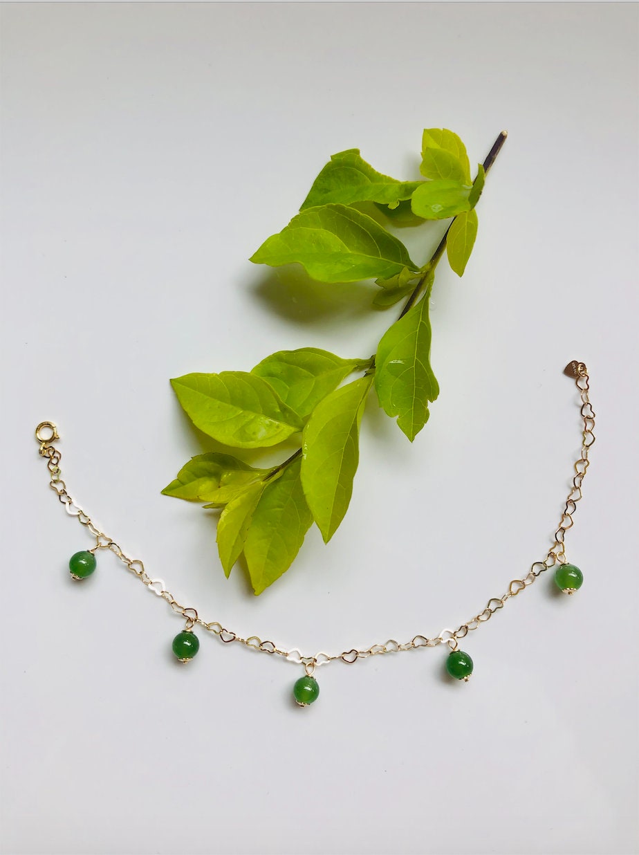 14k gold filled bracelet with green jade beads and heart charms with a leaf