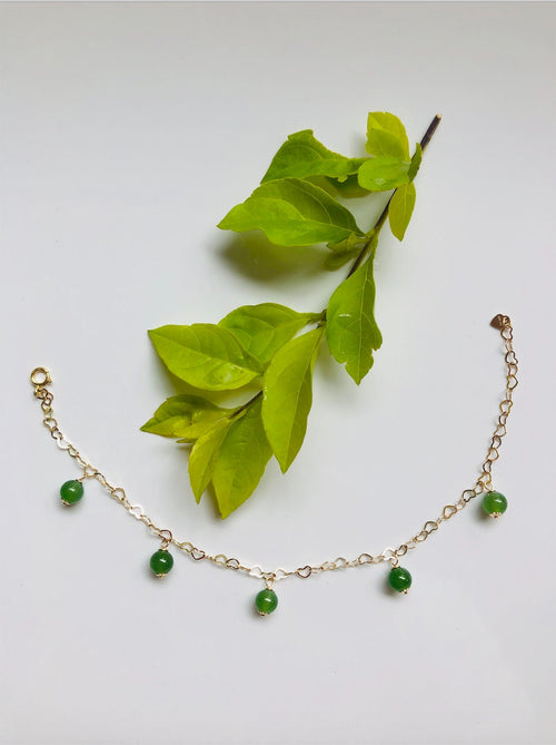 14k gold filled bracelet with green jade beads and heart charms with a leaf
