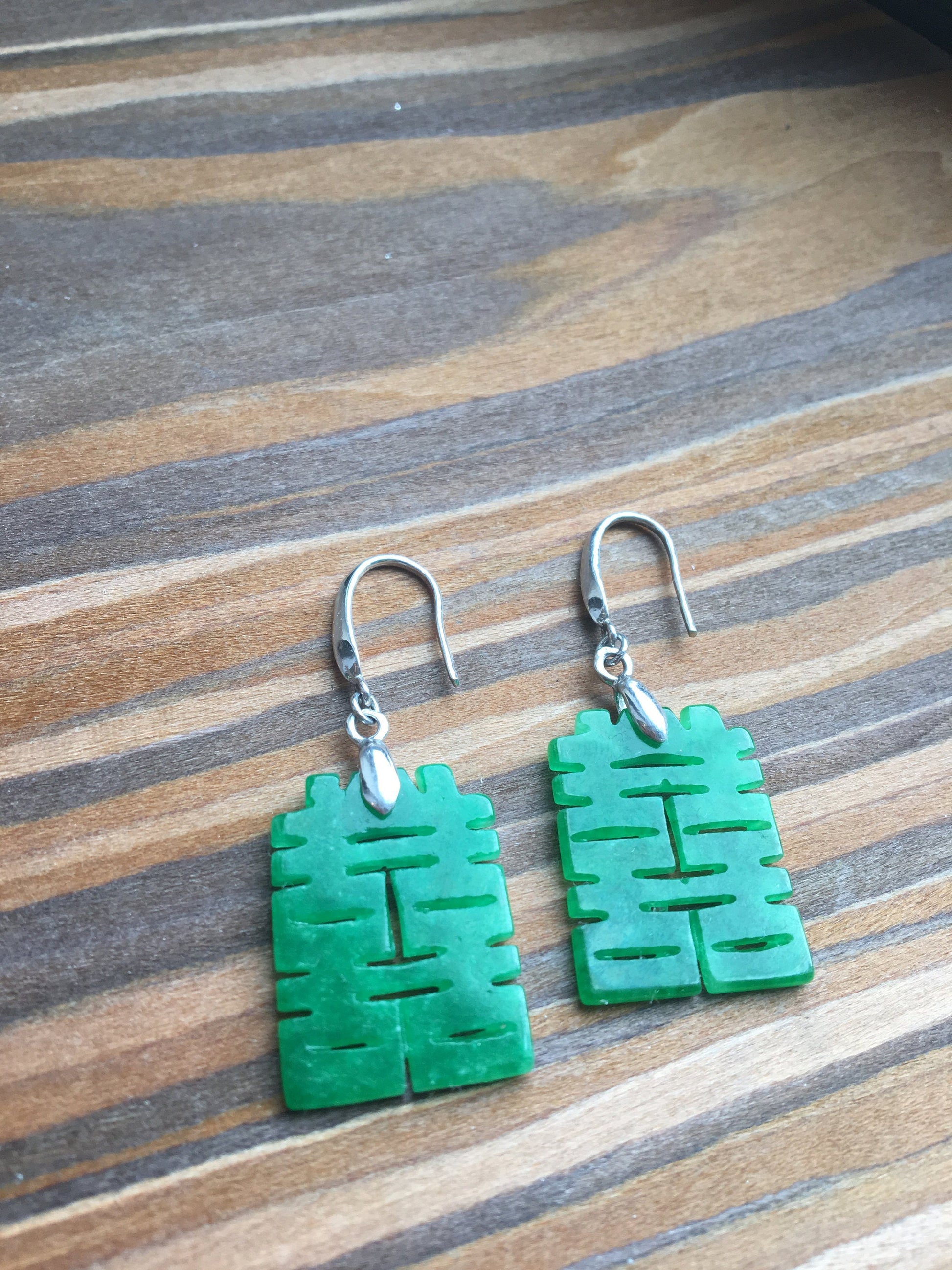 Close-up of genuine jade earrings with detailed Chinese double happiness charm
