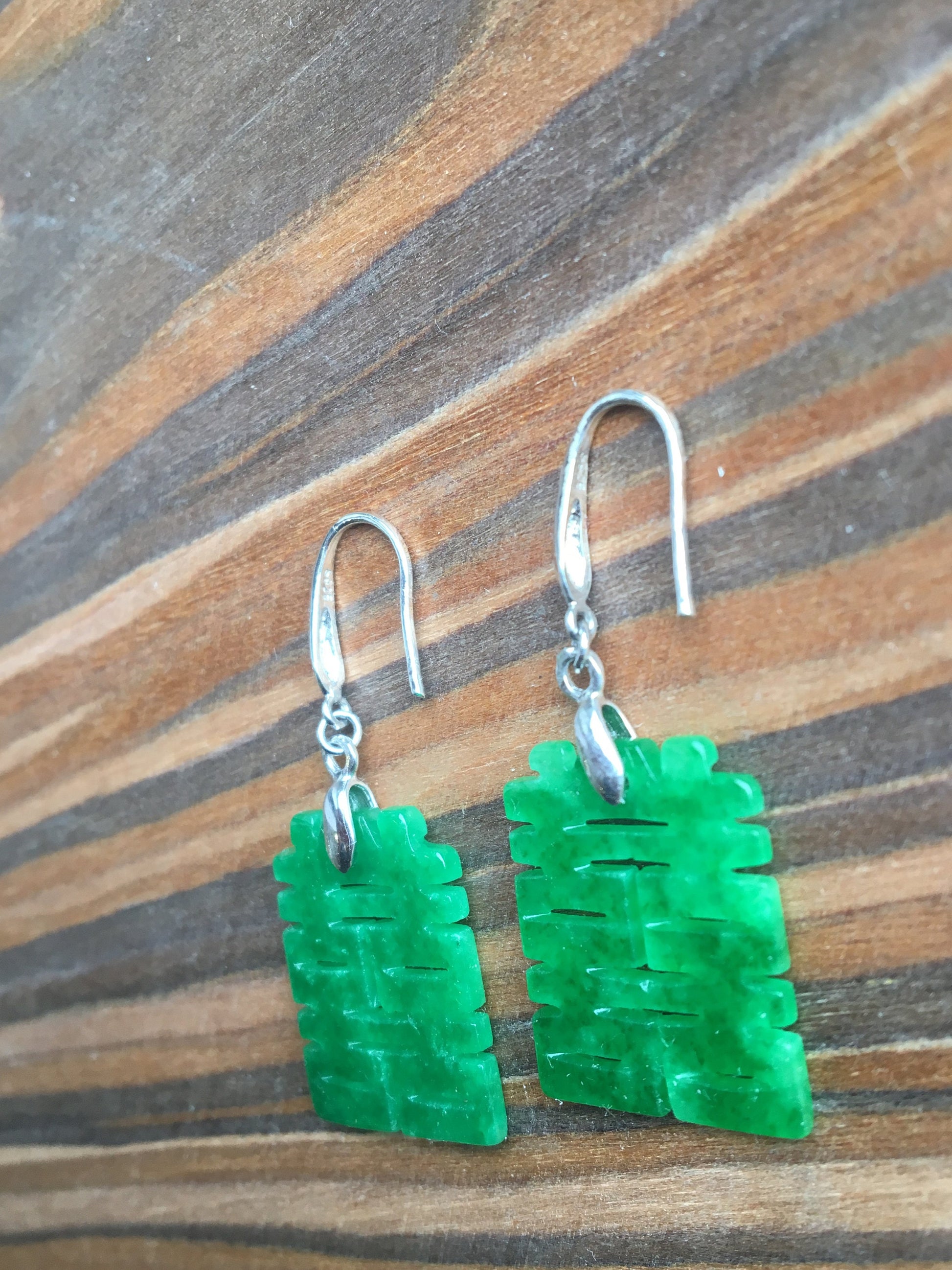 Side angle of jade dangle earrings featuring Chinese character design

