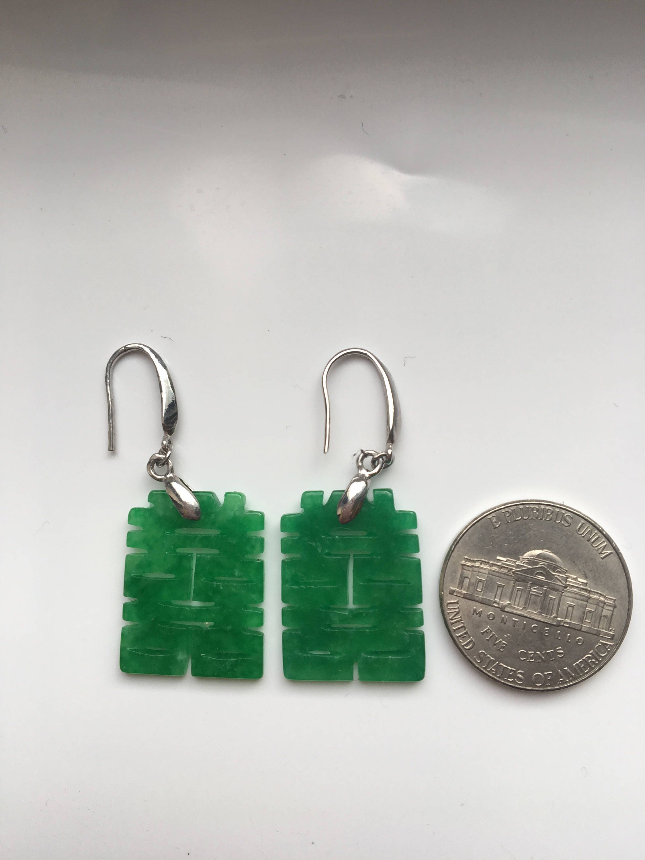 Jade dangle earrings shown next to coin for size reference