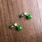 Pair of green bead earrings on a wooden surface