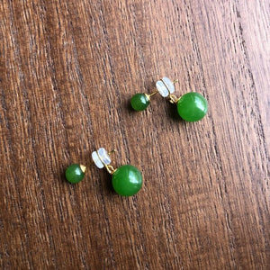 Pair of green bead earrings on a wooden surface