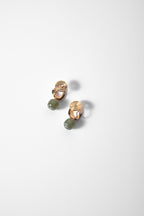 Close-up of different angled green jade clip-on hanging dot earrings showing natural jade texture and gold details