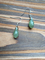 Green teardrop earrings on a wooden surface