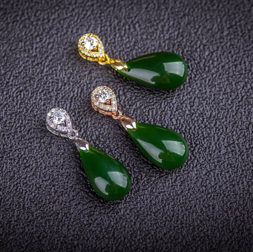 Close-up of natural green jade stone in teardrop shape with silver, rose gold and gold mounting