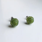 Green jade rose earrings viewed from side to show depth and carving detail of floral studs