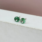 Side view of natural green jade stud earrings with silver settings