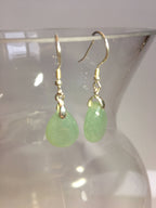 green jade earring hanging on the side of a vase