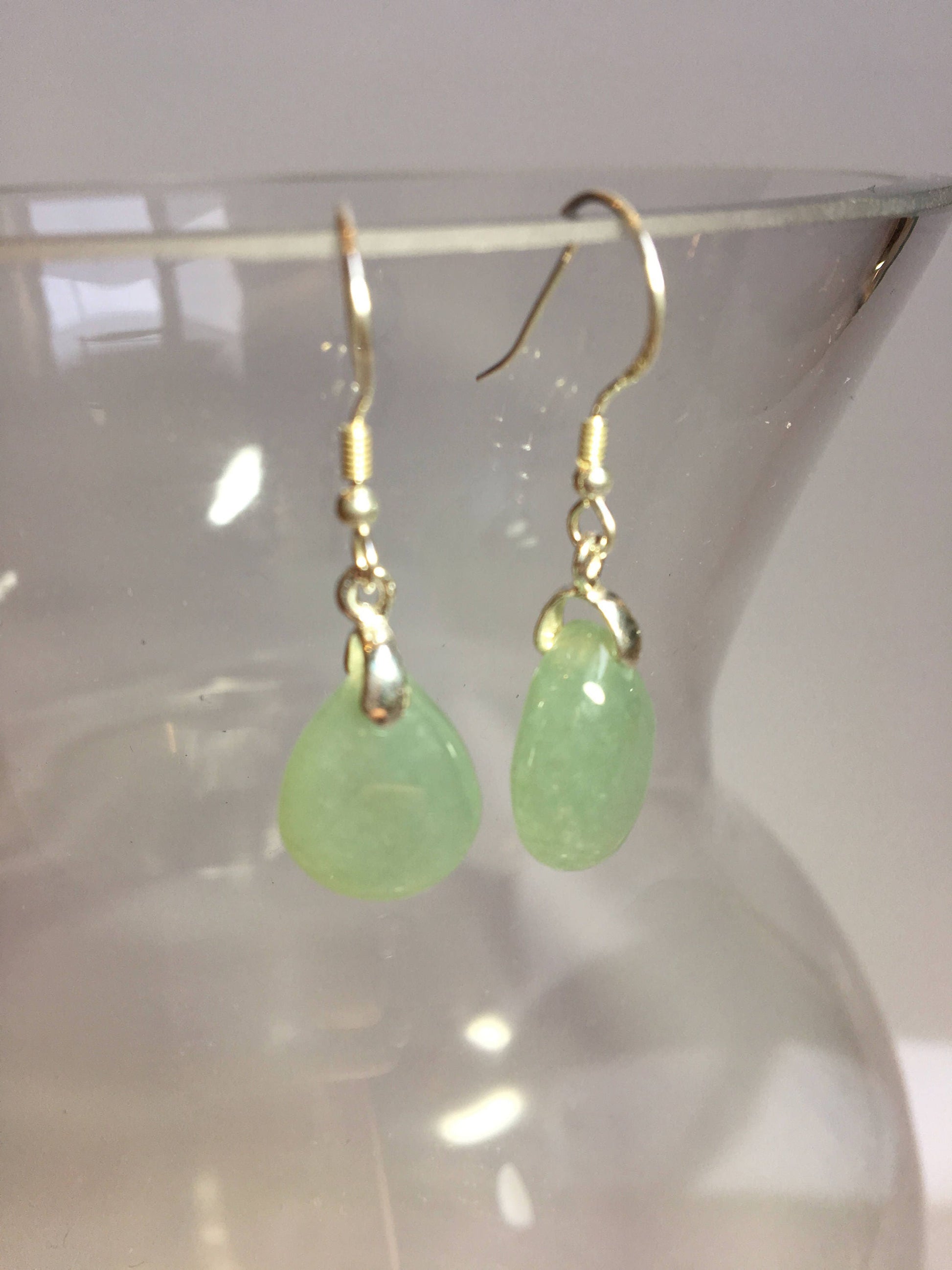 green jade earring hanging on the side of a vase