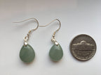 the green jade earrings compare with a coin for size reference