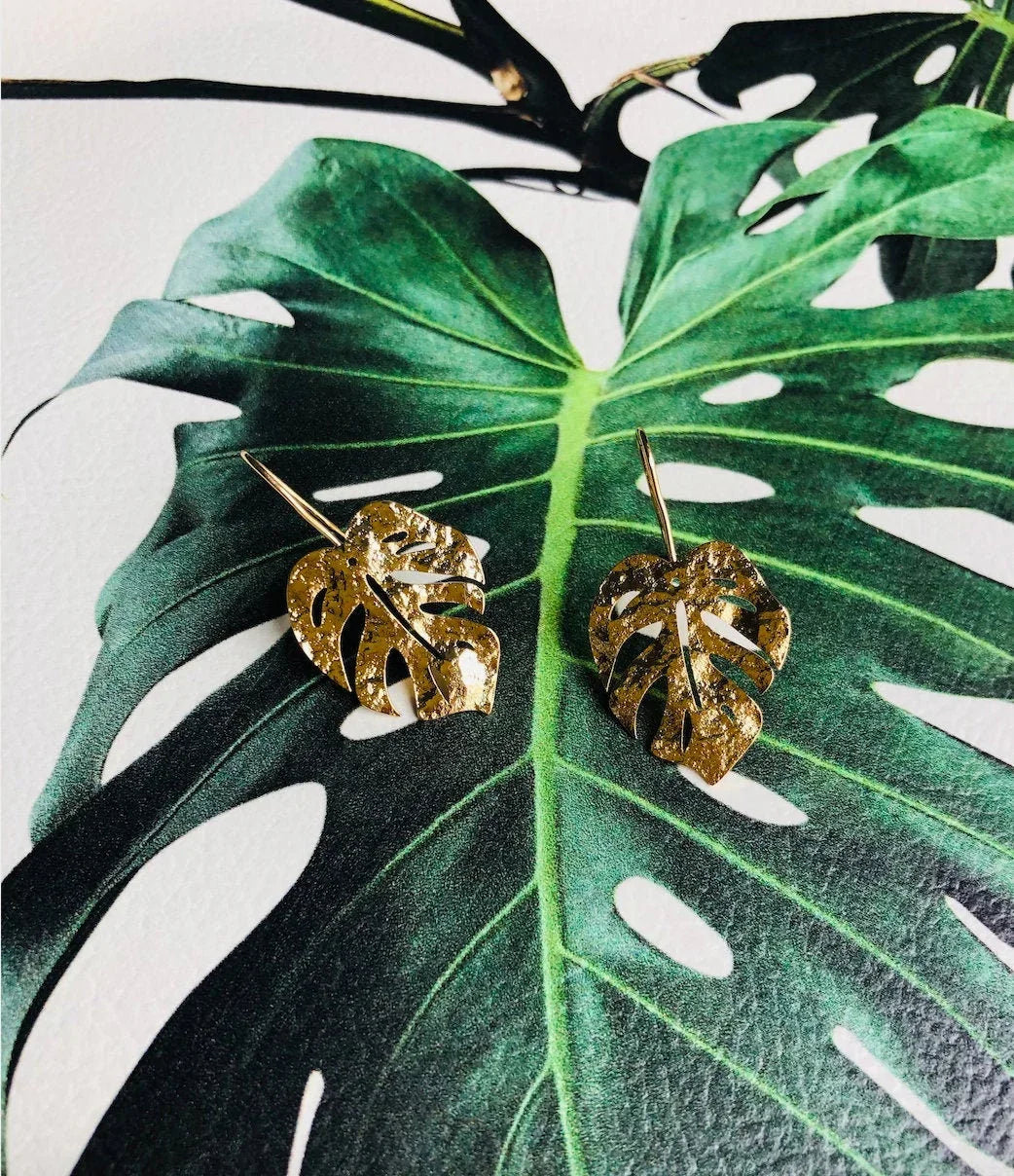 Glänzende goldene Monstera-Blatt-Ohrringe. Hängender tropischer Pflanzenschmuck. 14 Karat vergoldete Ohrringe. Naturinspiriert. Sommer-Strandparty-Schmuck.