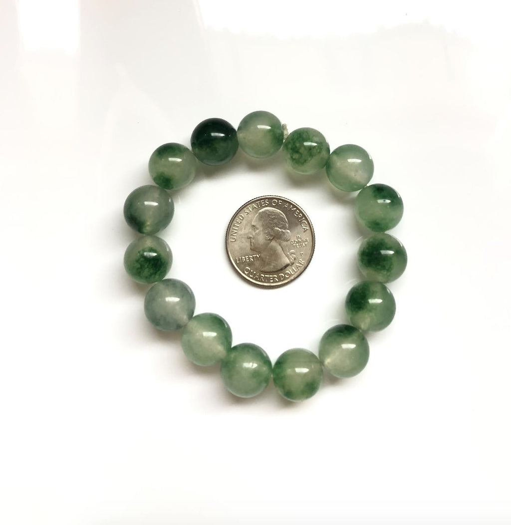Moss agate jade bracelet next to a US quarter coin for bead size comparison