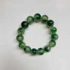 Close-up of green moss agate beads with visible stone texture and adjustable stretch cord