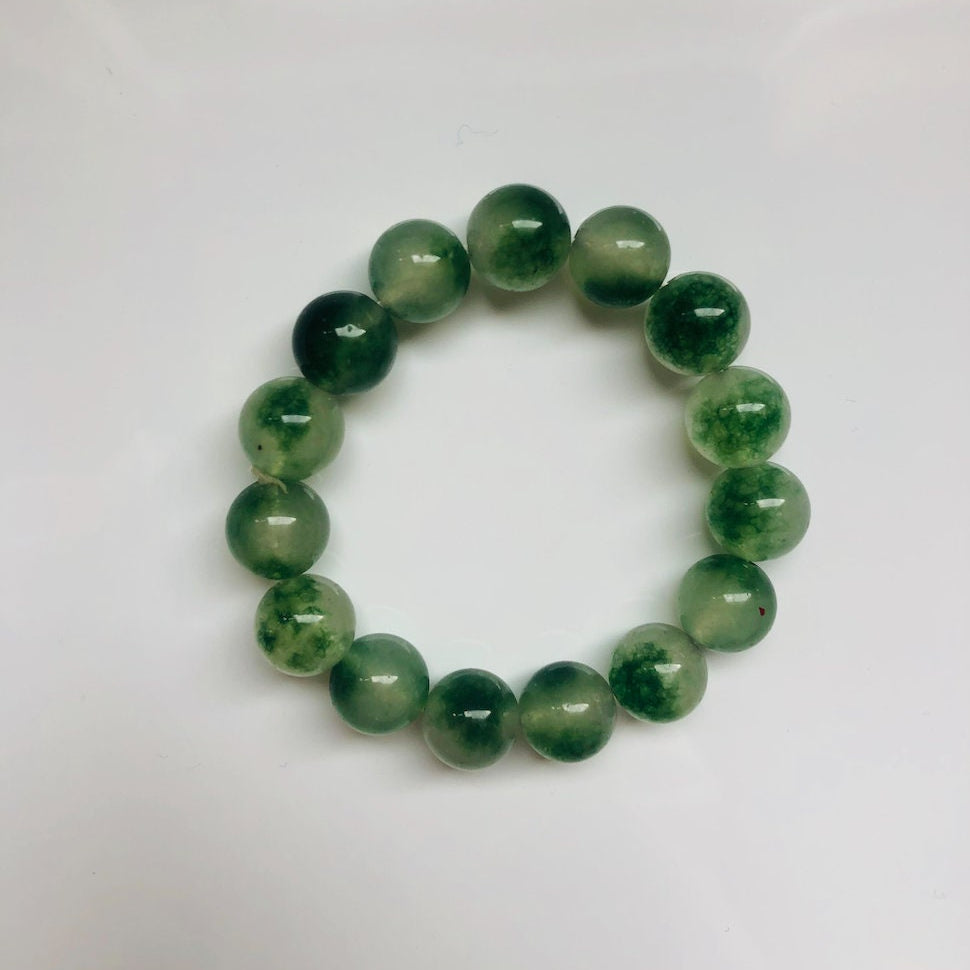Close-up of green moss agate beads with visible stone texture and adjustable stretch cord
