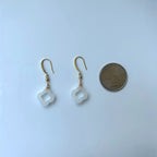 White jade clover earrings next to US quarter for size comparison