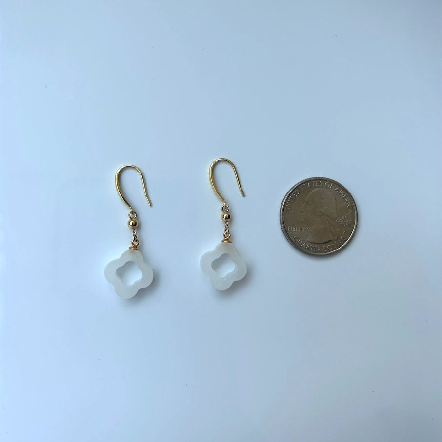 White jade clover earrings next to US quarter for size comparison