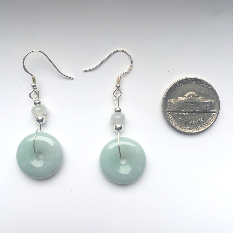 sage green jade donut earrings showing natural stone texture and silver setting next to a US quater coin for size reference