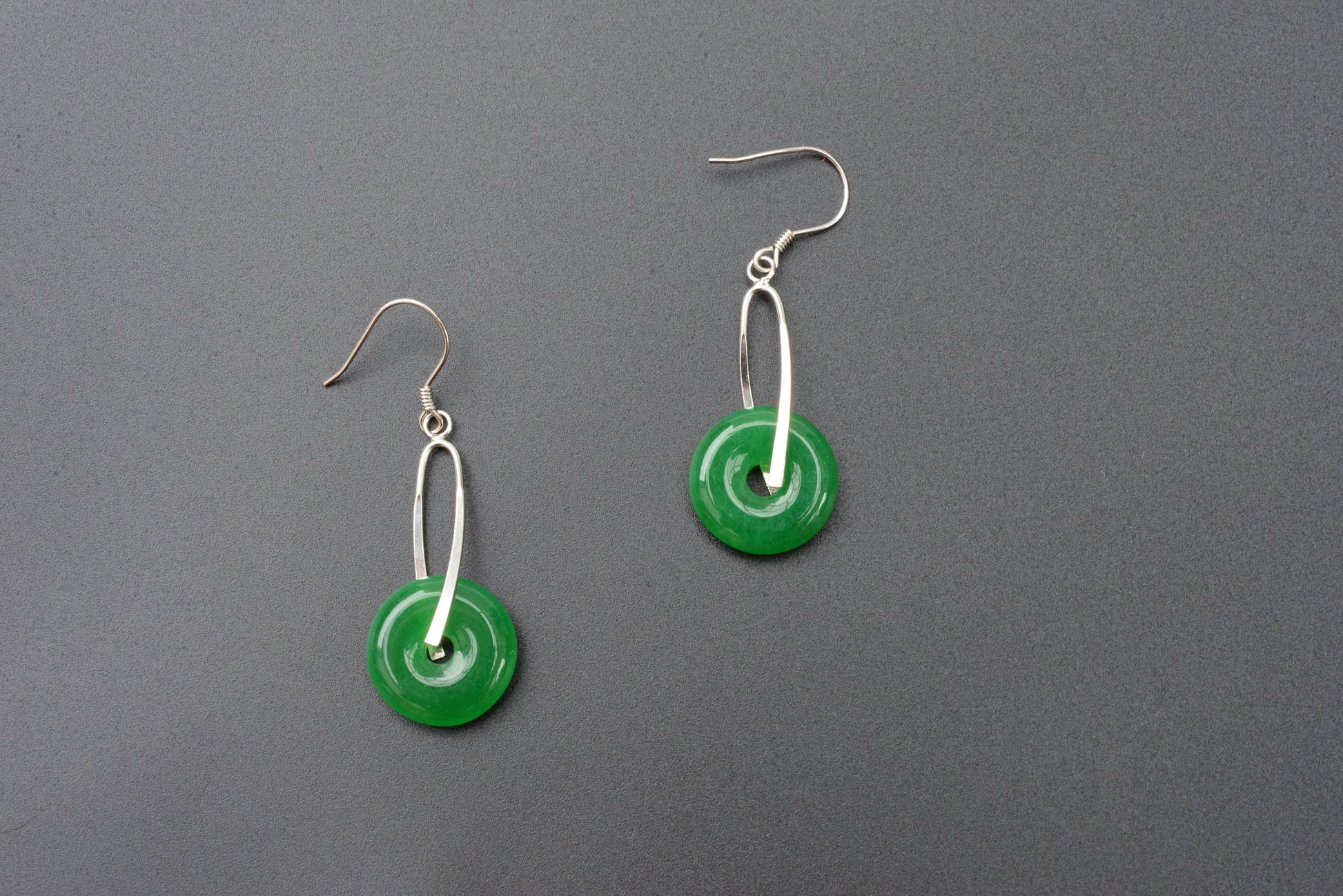 Side view of round Chinese jade earrings showing donut shape and silver dangle setting