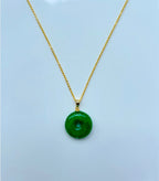 Front view of minimalist green jade donut necklace with 18k gold chain on a white background