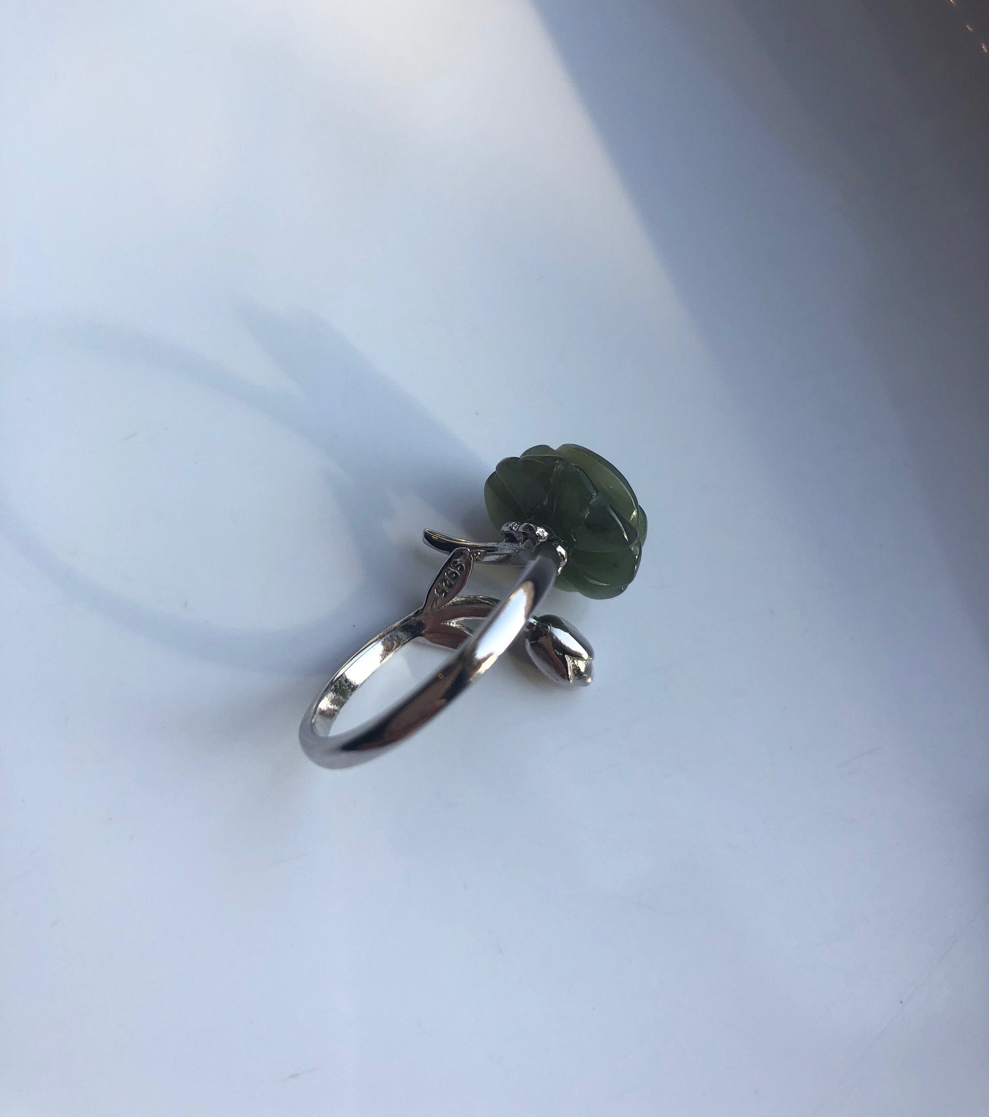 Close-up of jade rose carving and silver leaf band